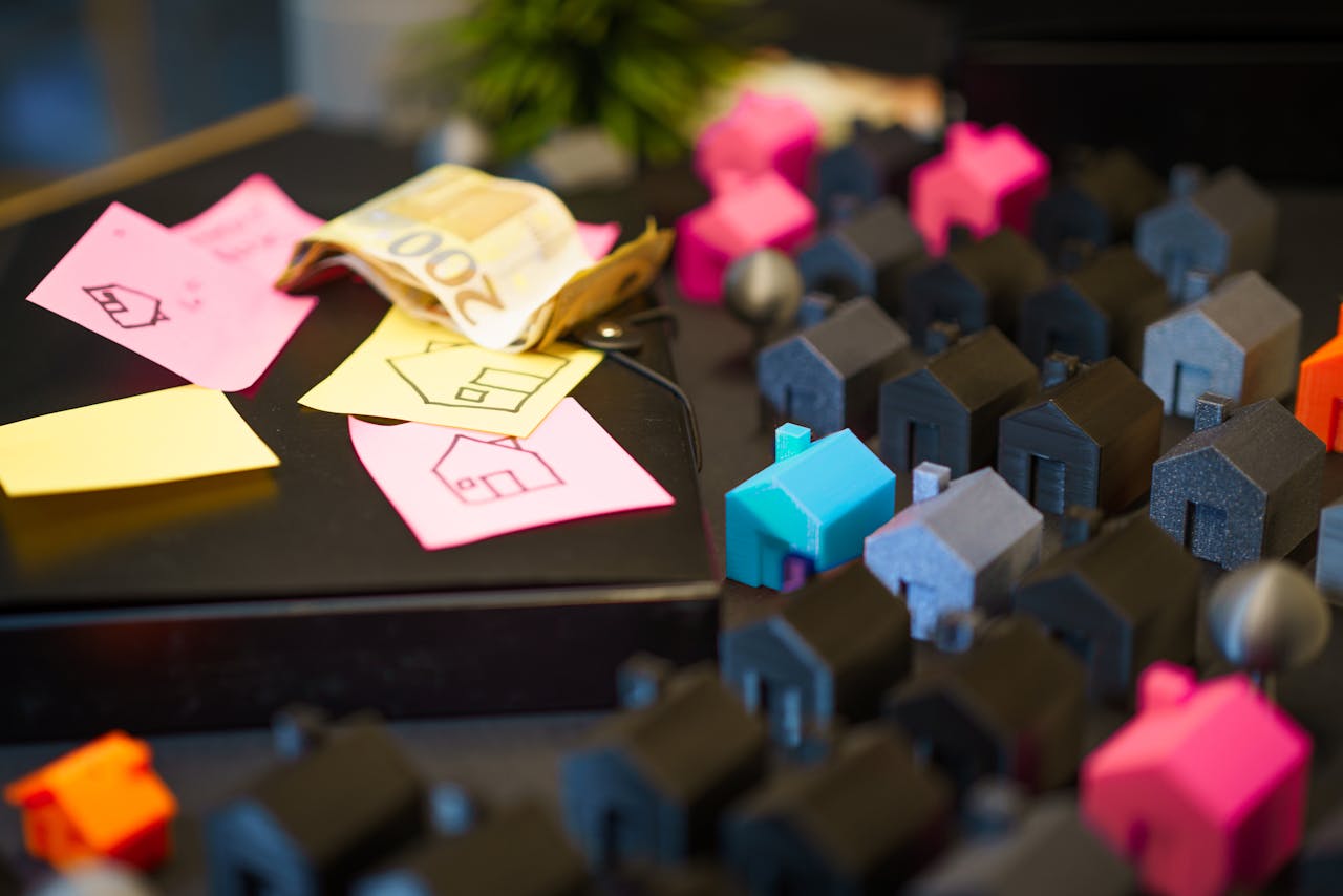 gallery-3 Colorful model houses next to Euro notes and sketches, showcasing real estate investment planning.